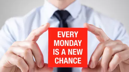 Business owner holding up a sign about every Monday being a new chance - a way to beat a case of the Mondays