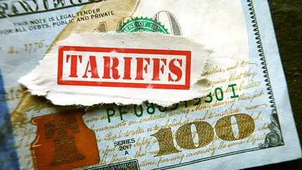 A US one hundred dollar bill beneath a banner that says "TARIFFS"