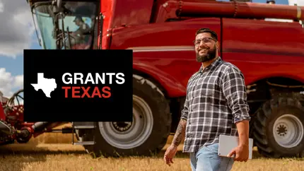 male business owner with farm equipment in the background, happy to look for grants in Texas