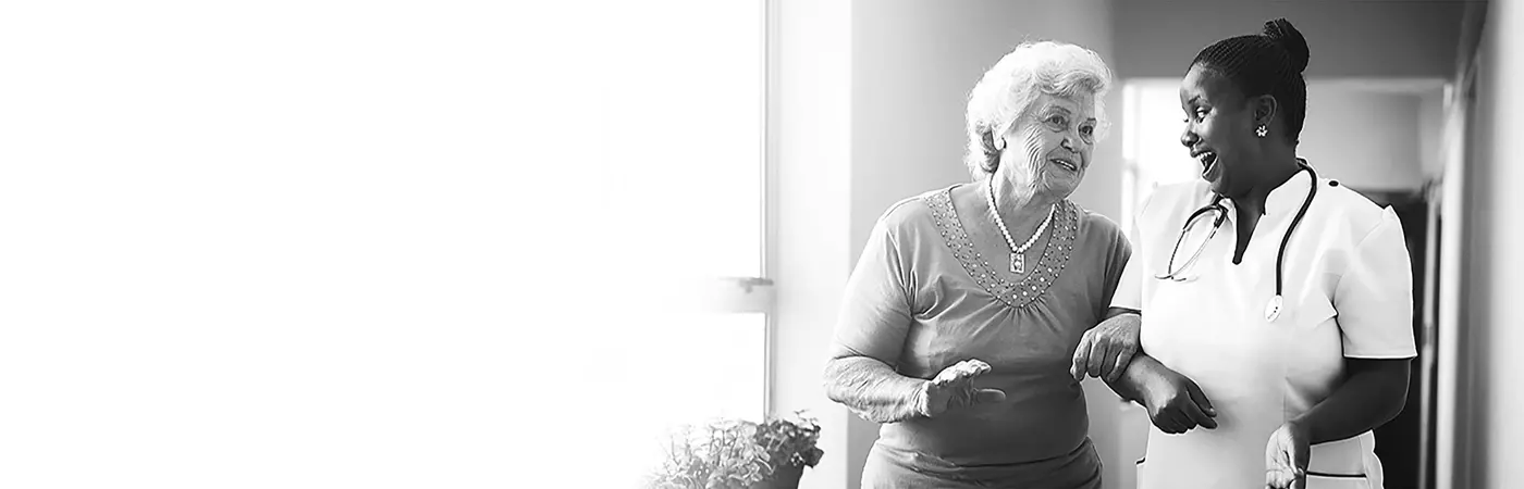 A health professional enjoying helping an elderly patient and enjoying her small business insurance