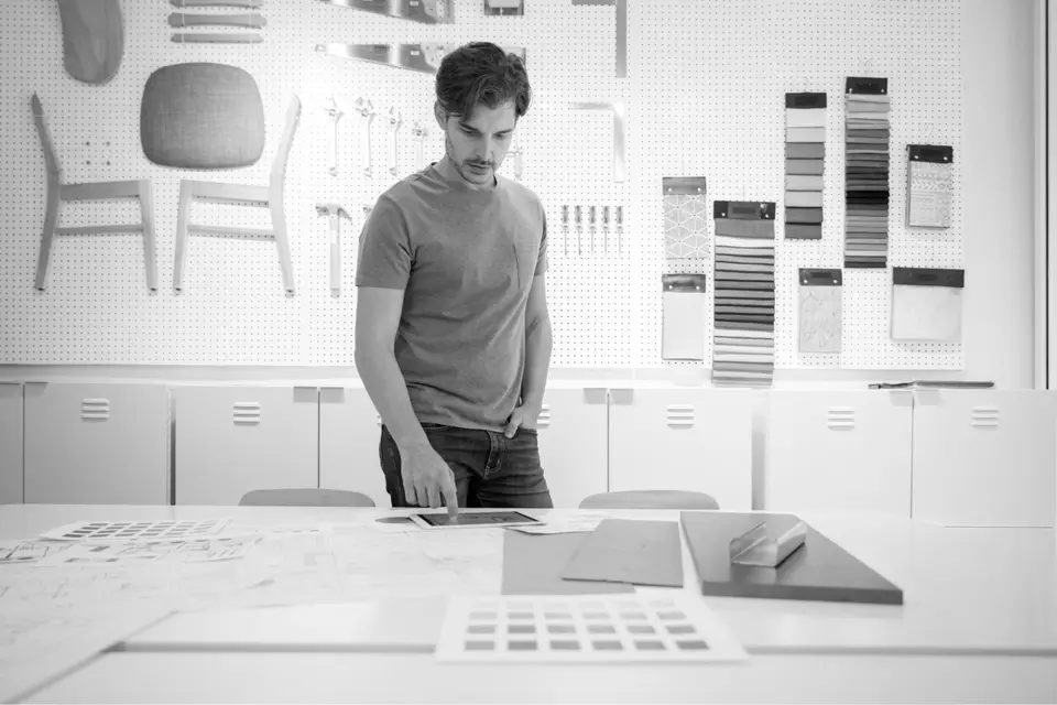 Interior Designer standing and looking at images and material samples