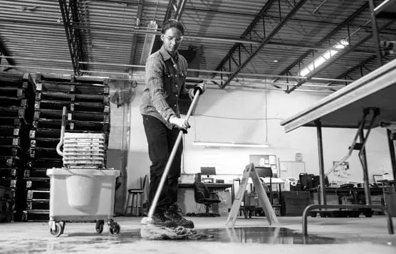 Janitor cleaning floor with mop and bucket