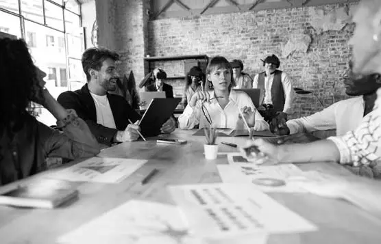 Marketers meeting around a table with graph charts