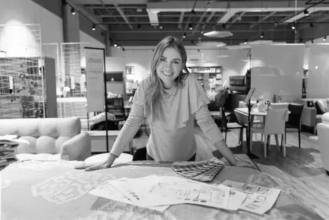 Interior Designer smiling and leaning over table with color and fabric samples