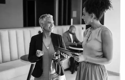 Business consultants talking to one another with a tablet in hand