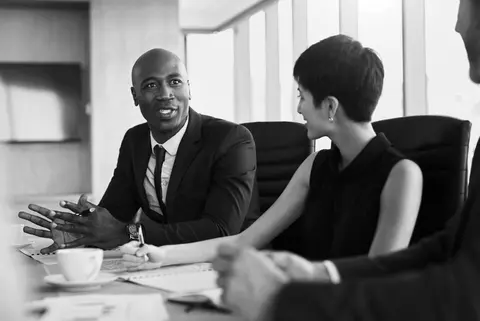 Legal services meeting of three people in a conference room