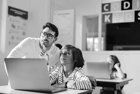 Tutor working with a student at a desk